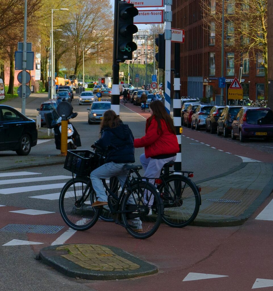 two women on bikes in city scene
